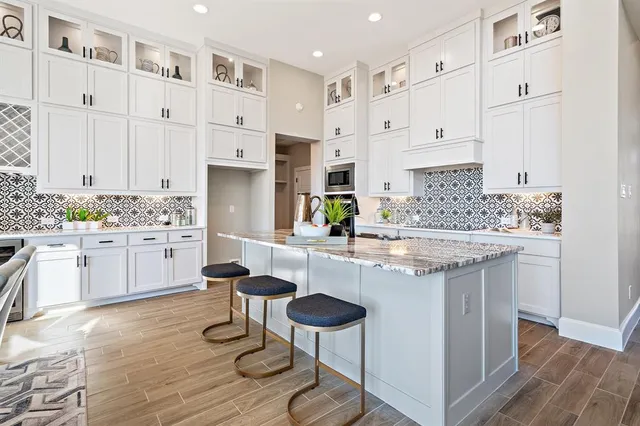 a kitchen with white cabinets and sink