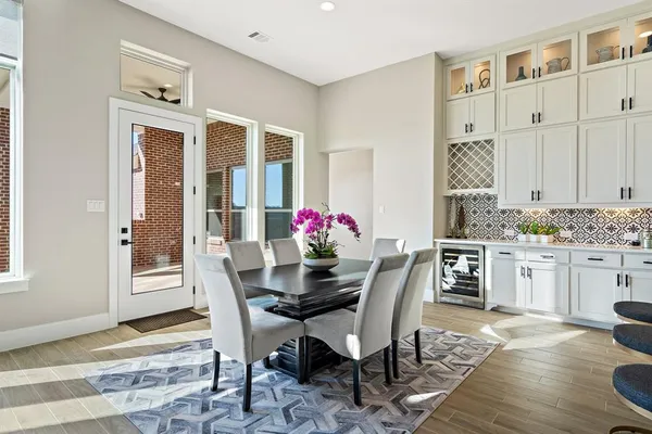 a dining room with furniture potted plants and wooden floor