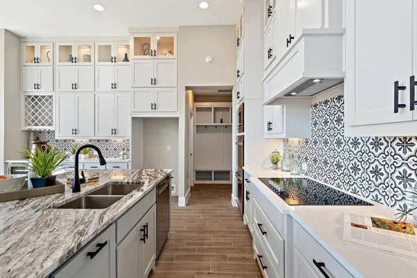 a kitchen with stainless steel appliances granite countertop a sink a stove and refrigerator
