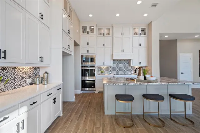 a large kitchen with stainless steel appliances kitchen island granite countertop wooden cabinets and a granite counter tops