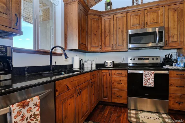 a kitchen with stainless steel appliances granite countertop a stove a sink and a microwave