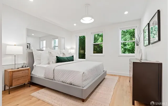 a bedroom with a large bed and wooden floor