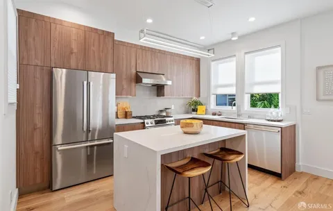 a kitchen with stainless steel appliances a stove a refrigerator and a sink