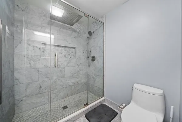 a white toilet next to a bathroom shower