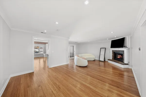 a view of empty room with wooden floor and fireplace