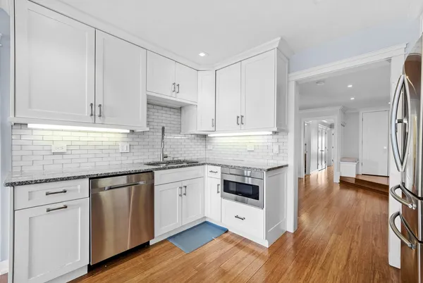 a kitchen with granite countertop white cabinets and white appliances