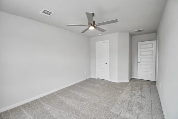 an empty room with windows and fan