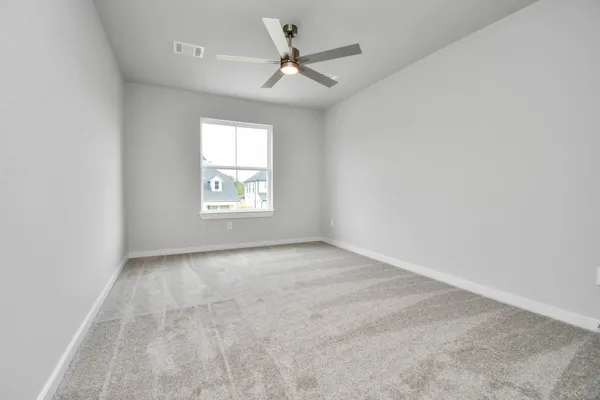 an empty room with a window and a fan