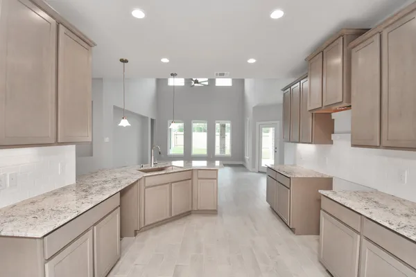 a large white kitchen with a lot of counter space and appliances