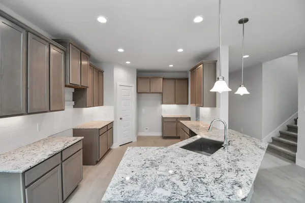 a kitchen with a sink a stove a refrigerator and cabinets