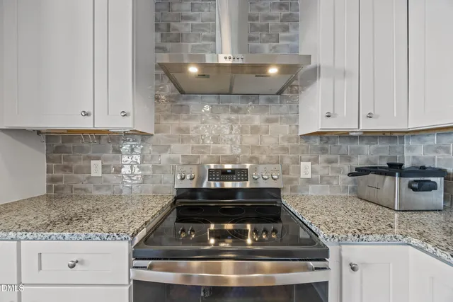 a kitchen with granite countertop a stove and a sink