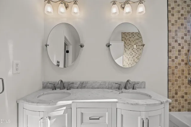 a bathroom with double vanity sinks and a mirror