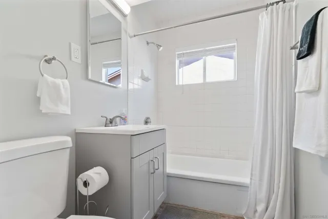 a bathroom with a sink mirror vanity and toilet