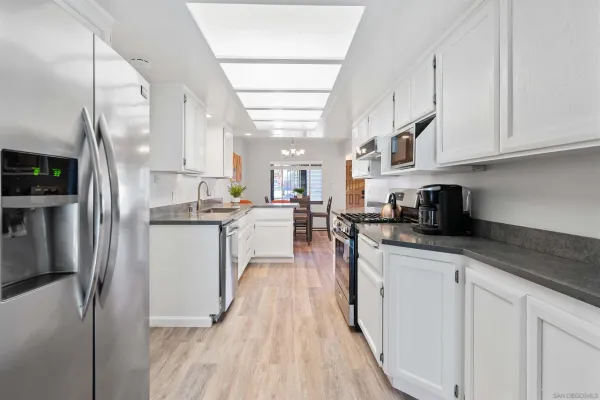 a kitchen with white cabinets and stainless steel appliances
