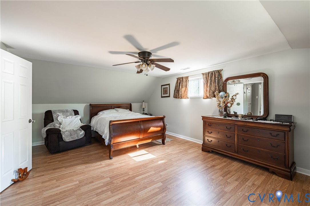 9217 Fisk Road Richmond, VA 23229 - Photo 26 of 39 a bedroom with a bed and wooden floor