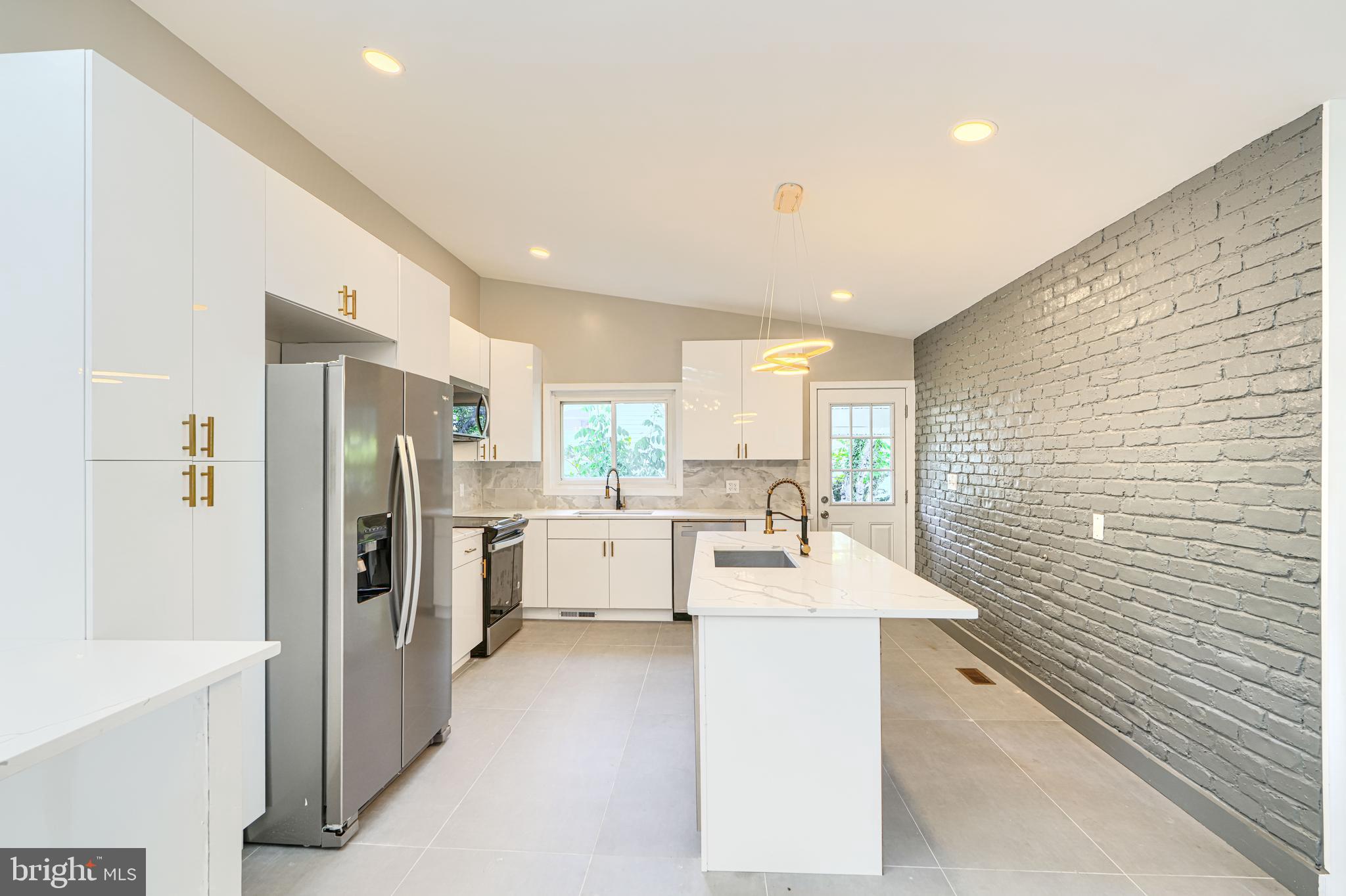 6200 Ivymount Road Baltimore, MD 21209 - Photo 13 of 71 a large white kitchen with a refrigerator a sink a stove and white cabinets