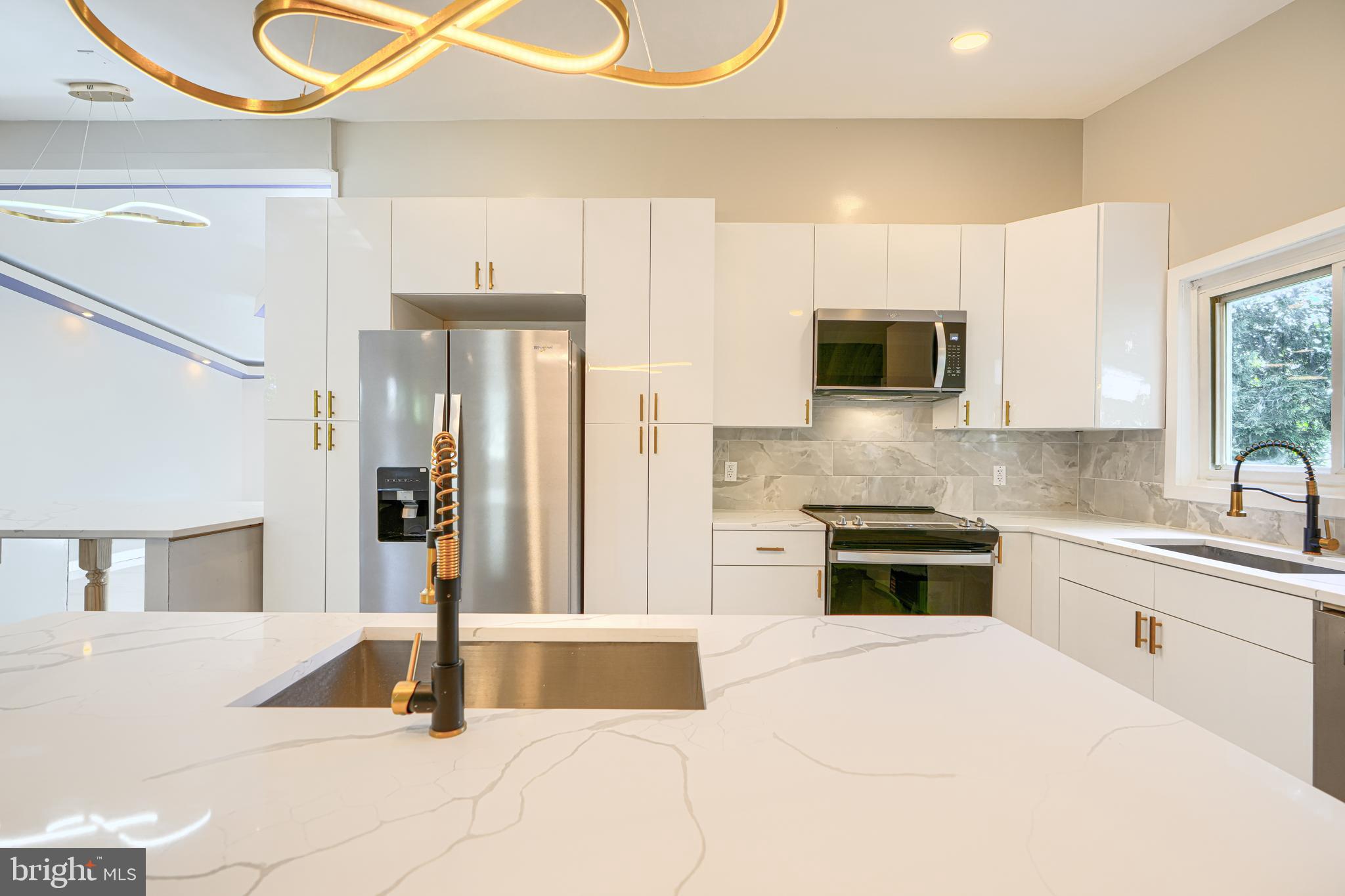 6200 Ivymount Road Baltimore, MD 21209 - Photo 16 of 71 a kitchen with stainless steel appliances kitchen island granite countertop a refrigerator and a stove top oven