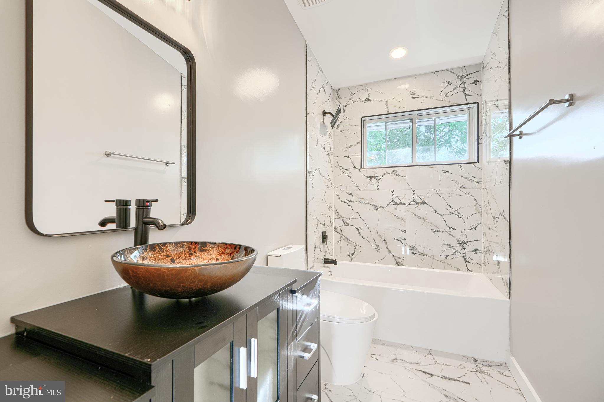 6200 Ivymount Road Baltimore, MD 21209 - Photo 32 of 71 a bathroom with a bathtub a sink and a mirror