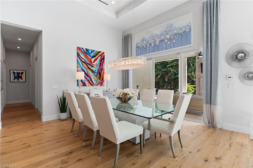 720 Orchid Drive Naples, FL 34102 - Photo 13 of 50 a view of a dining room with furniture and wooden floor