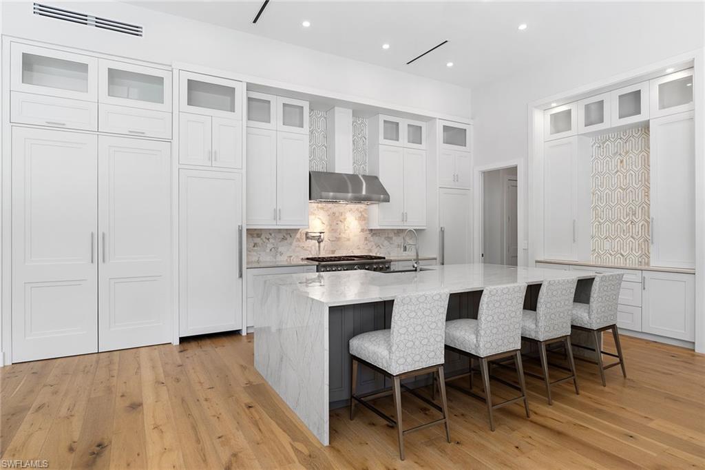 720 Orchid Drive Naples, FL 34102 - Photo 15 of 50 a kitchen with a sink cabinets and dining table chair