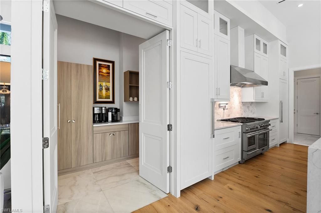 720 Orchid Drive Naples, FL 34102 - Photo 17 of 50 a kitchen with stainless steel appliances granite countertop a refrigerator and a stove top oven
