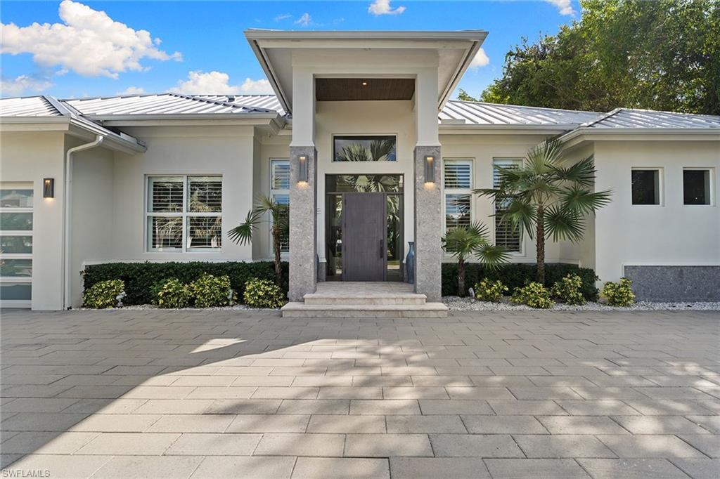 720 Orchid Drive Naples, FL 34102 - Photo 2 of 50 a front view of a house with a yard