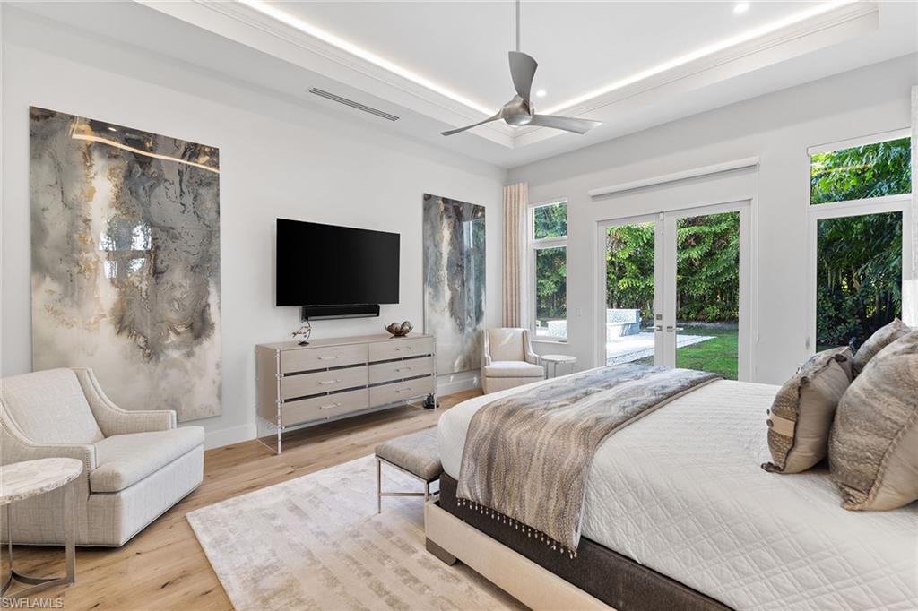 720 Orchid Drive Naples, FL 34102 - Photo 26 of 50 a bedroom with a bed television and a large window