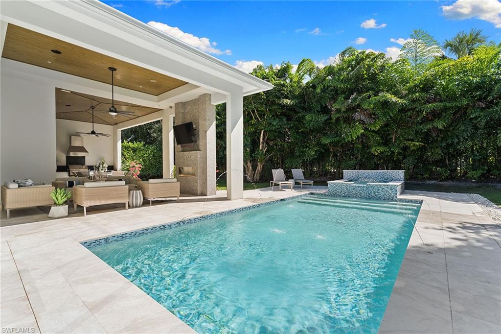 720 Orchid Drive Naples, FL 34102 - Photo 34 of 50 a view of a patio with table and chairs and potted plants