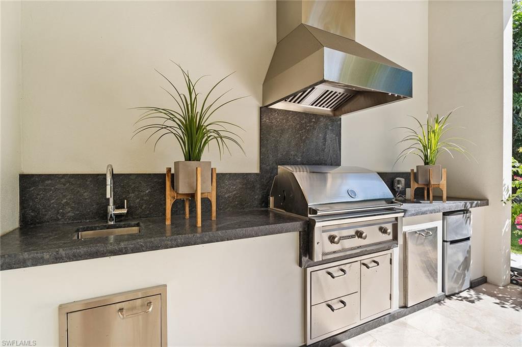 720 Orchid Drive Naples, FL 34102 - Photo 42 of 50 a kitchen with stainless steel appliances granite countertop a stove a sink and a microwave