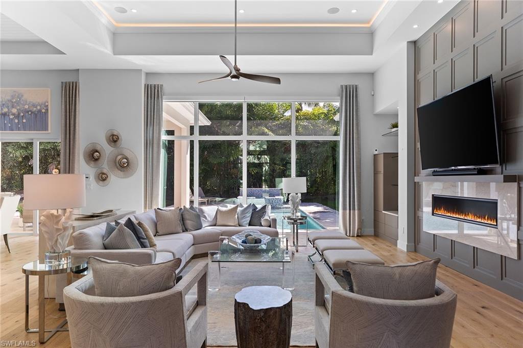 720 Orchid Drive Naples, FL 34102 - Photo 5 of 50 a living room with furniture a flat screen tv and a large window