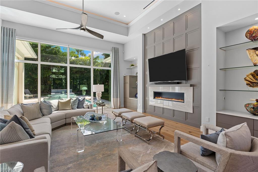 720 Orchid Drive Naples, FL 34102 - Photo 7 of 50 a living room with furniture a flat screen tv and a fireplace