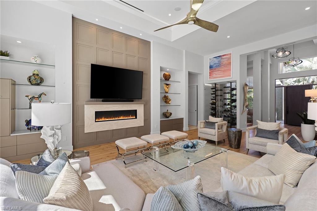 720 Orchid Drive Naples, FL 34102 - Photo 9 of 50 a living room with furniture a flat screen tv and a fireplace