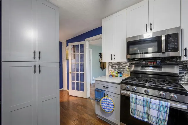 a kitchen with stainless steel appliances a stove a microwave and cabinets