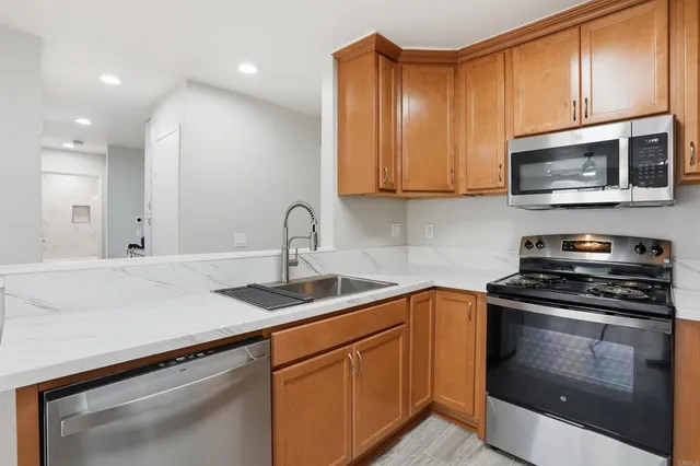 a kitchen with stainless steel appliances granite countertop a sink stove and microwave