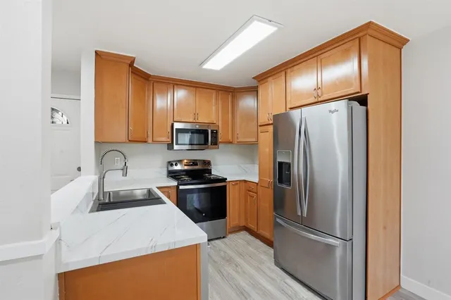 a kitchen with stainless steel appliances granite countertop a refrigerator stove microwave and sink