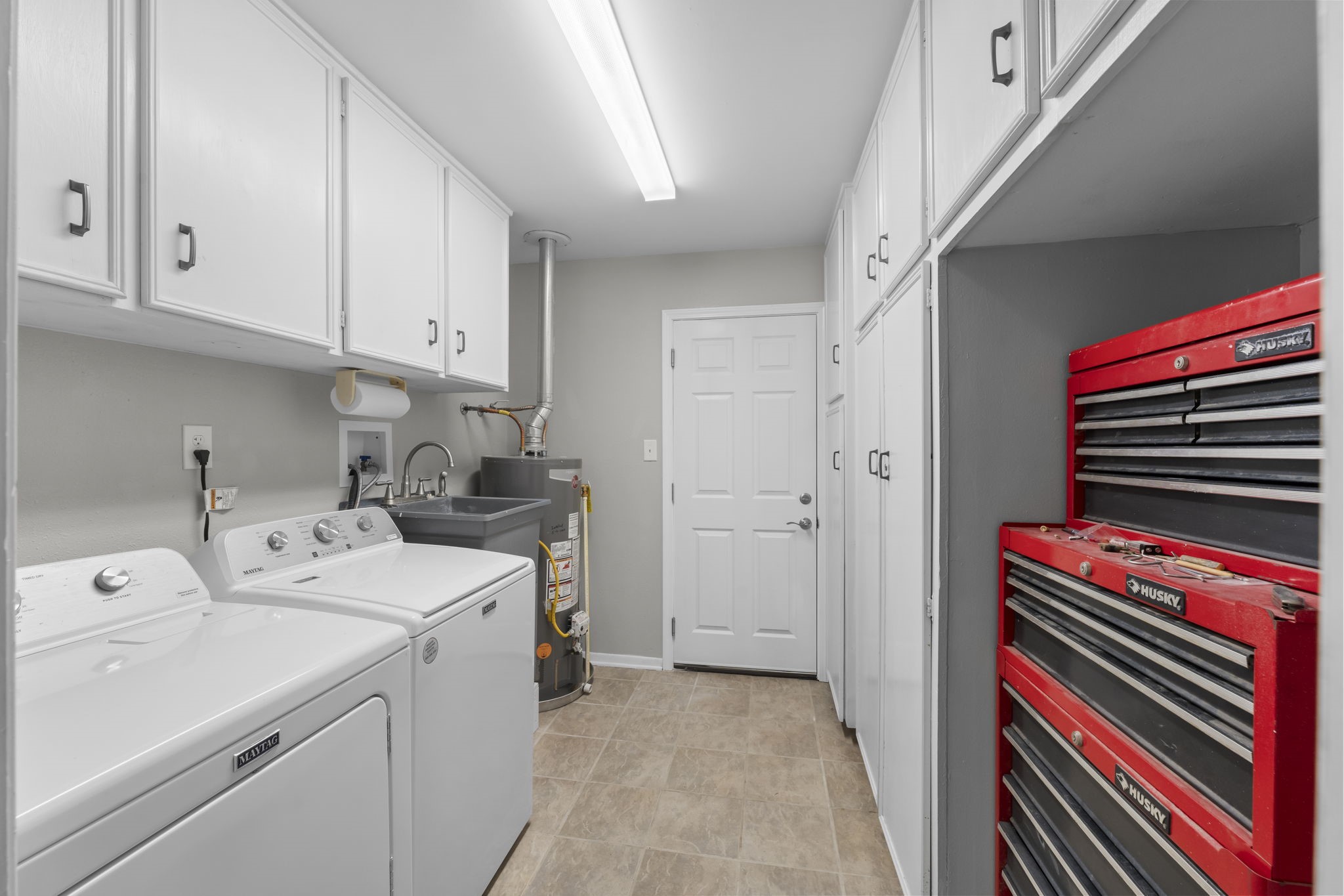 209 Summit Drive Conroe, TX 77303 - Photo 17 of 22 The laundry room is equipped with a washing basin, ample storage cabinets, and extra space for a fridge or freezer; perfect for added pantry overflow or utility needs.