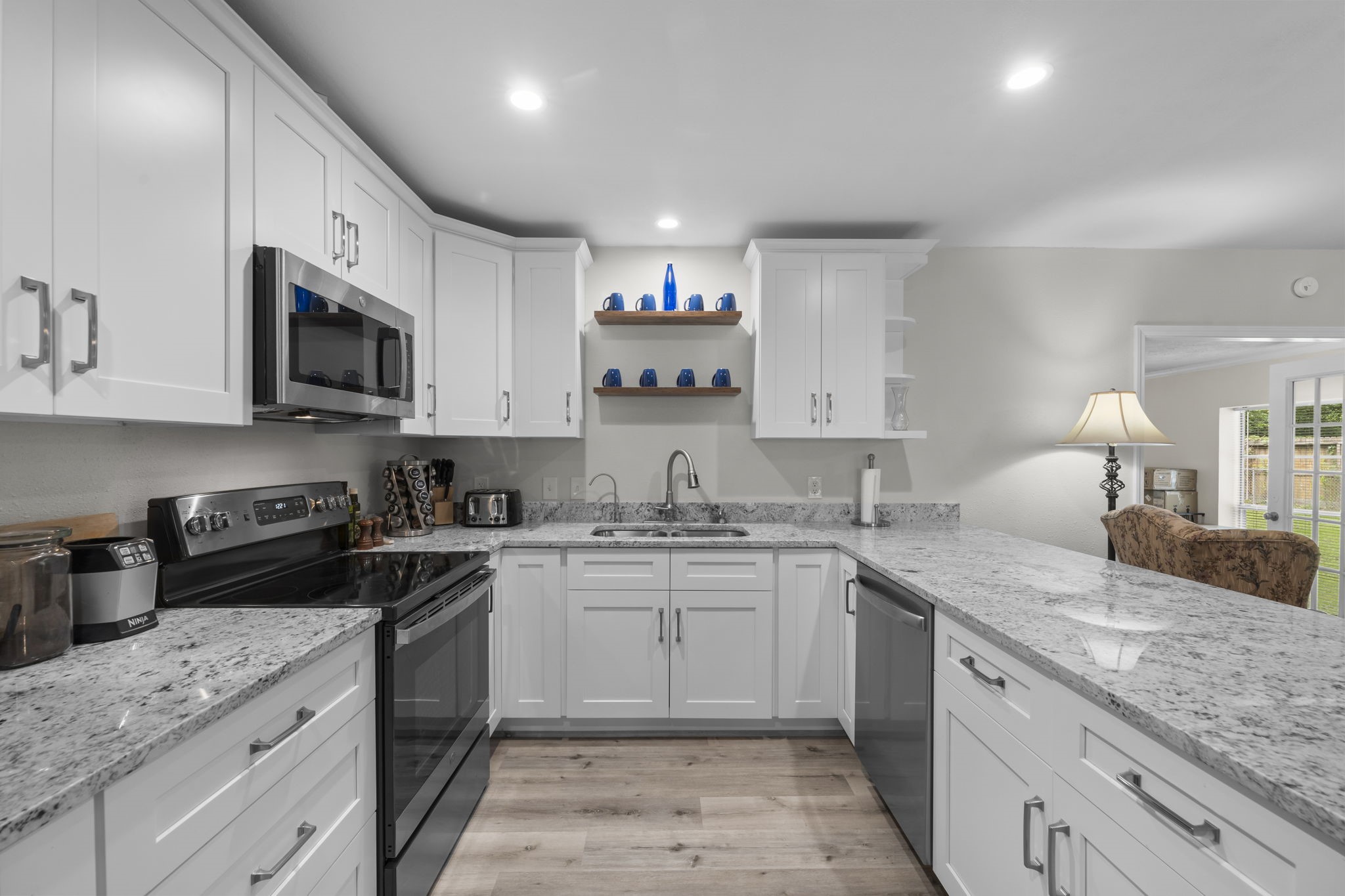 209 Summit Drive Conroe, TX 77303 - Photo 4 of 22 Step into a stunning, fully renovated kitchen featuring sleek granite countertops, soft-close custom cabinetry, water filtration system, and a full suite of brand-new stainless steel appliances.