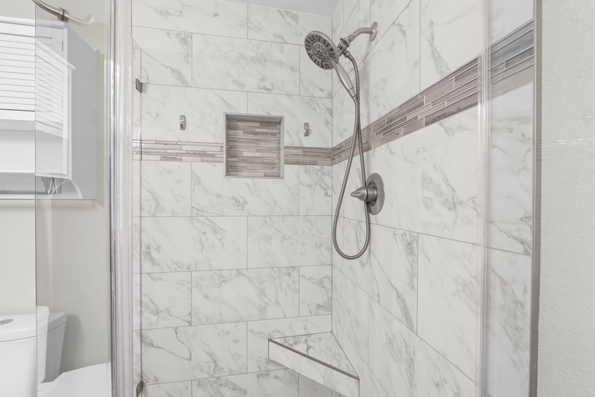 209 Summit Drive Conroe, TX 77303 - Photo 7 of 22 This close-up of the shower tile highlights the exceptional craftsmanship; meticulous detail, quality materials, and no corners cut in this stunning renovation.