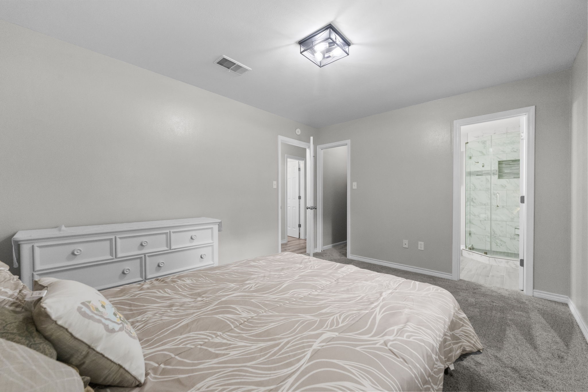209 Summit Drive Conroe, TX 77303 - Photo 8 of 22 The spacious primary bedroom offers fresh paint, brand-new carpet, and a view into the beautifully renovated en-suite bathroom.