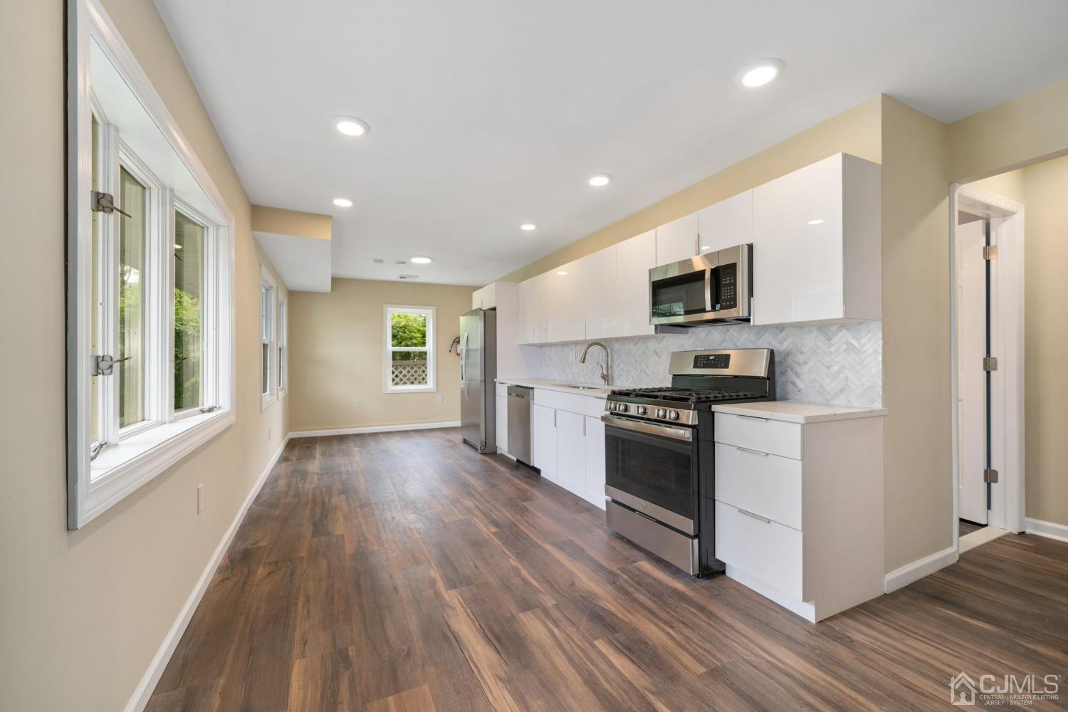 68 Winthrop Road Edison, NJ 08817 - Photo 4 of 19 a kitchen with stainless steel appliances granite countertop a stove top oven a sink dishwasher a refrigerator and a microwave oven with wooden floor
