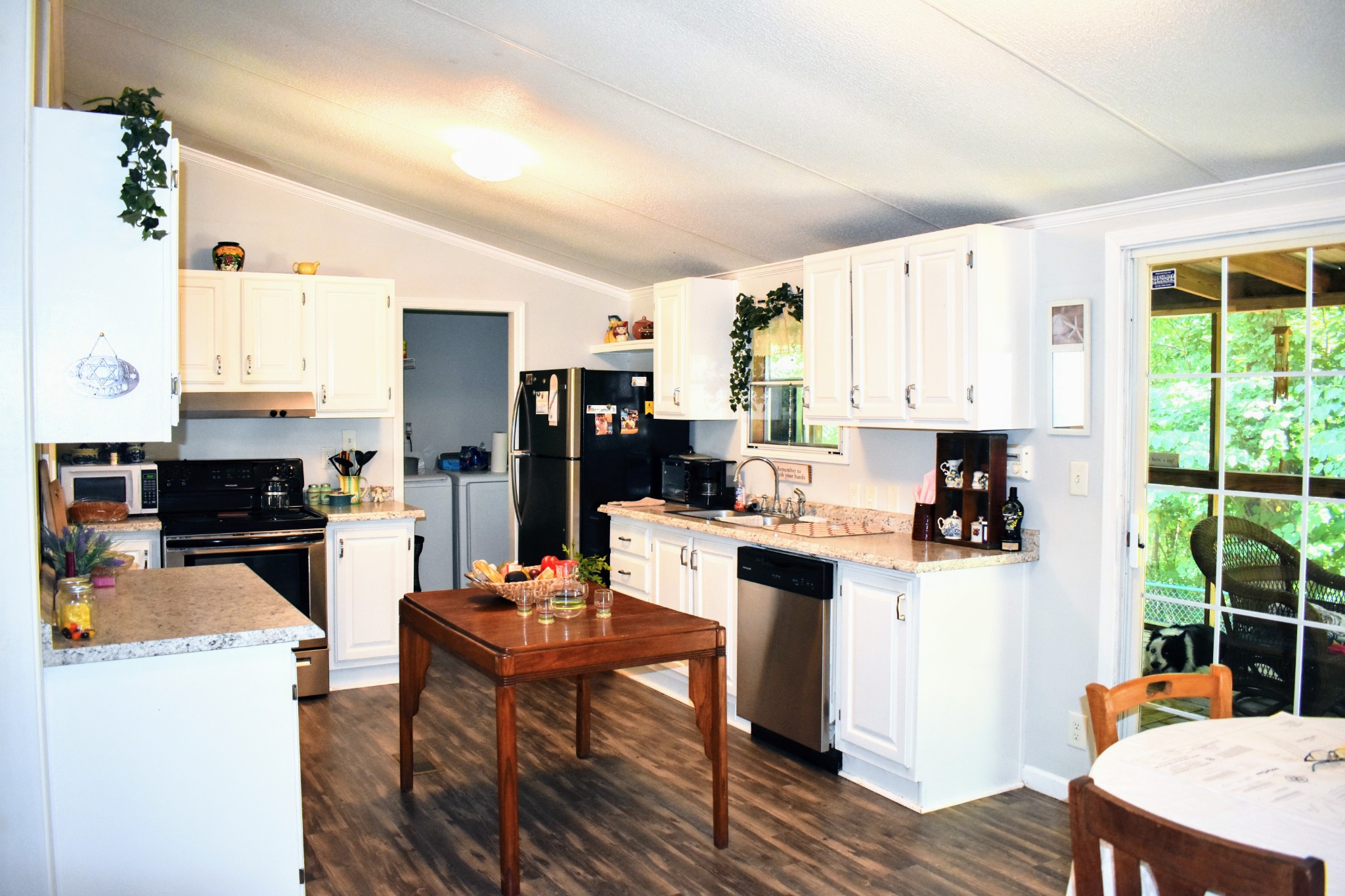 2630 Jernigans Branch Road Beechgrove, TN 37018 - Photo 9 of 17 a kitchen with stainless steel appliances kitchen island granite countertop a refrigerator a stove top oven a sink dishwasher and white cabinets with wooden floor
