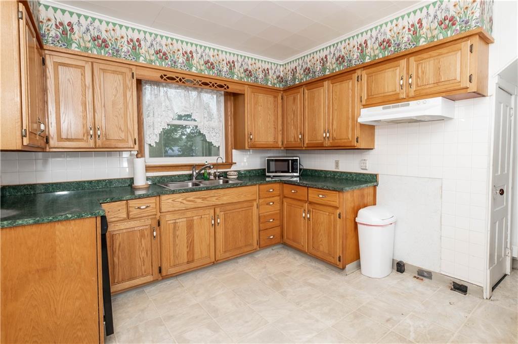 845 Grisemore Road Clymer, PA 15728 - Photo 8 of 21 a kitchen with granite countertop a stove a sink and a microwave