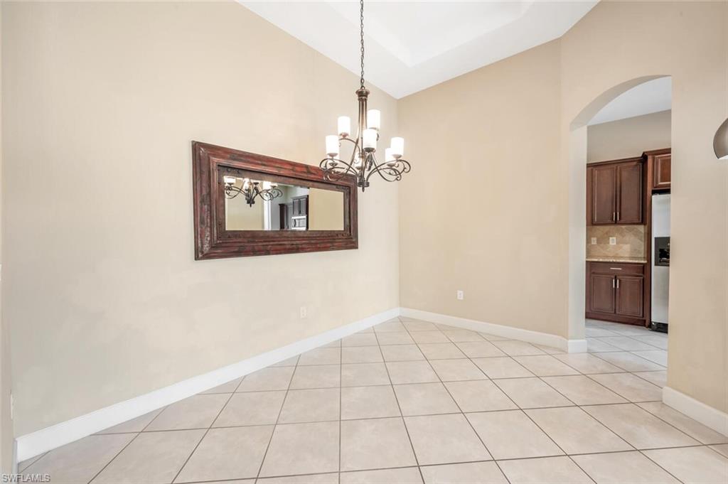 7975 Princeton Drive Naples, FL 34104 - Photo 12 of 28 a view of an empty room with a chandelier