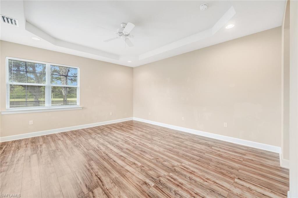 7975 Princeton Drive Naples, FL 34104 - Photo 15 of 28 wooden floor in an empty room with a window