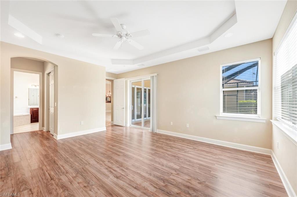 7975 Princeton Drive Naples, FL 34104 - Photo 16 of 28 a view of an empty room with wooden floor and a window