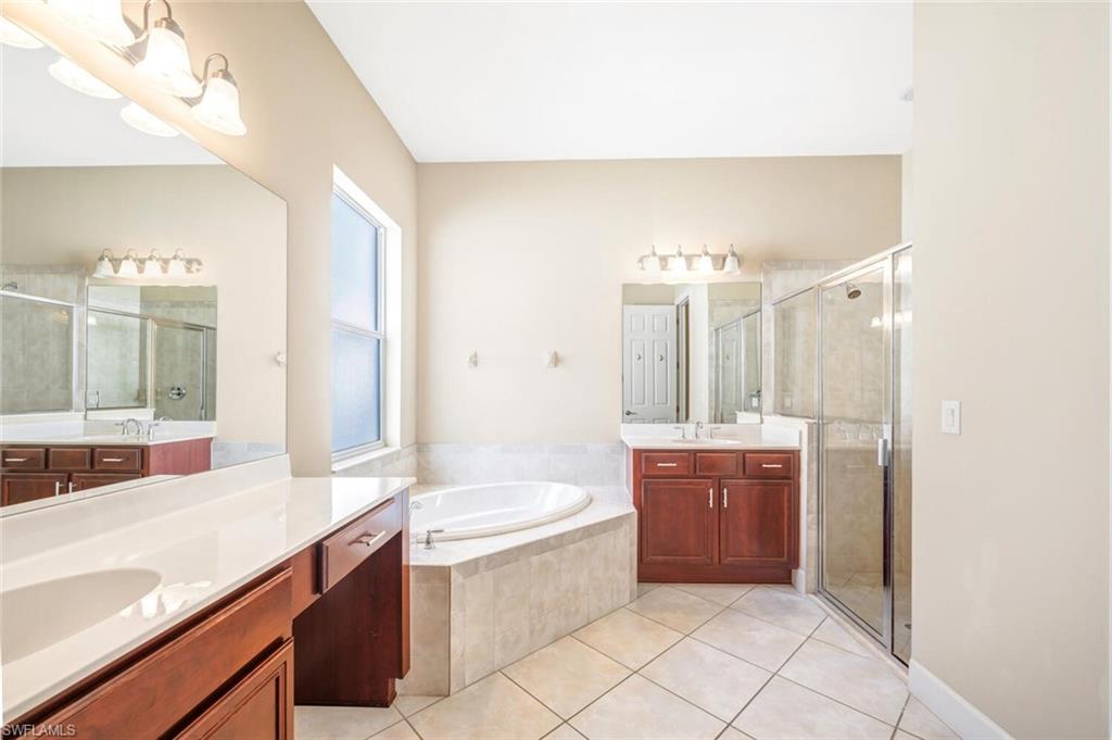 7975 Princeton Drive Naples, FL 34104 - Photo 17 of 28 a large bathroom with a double vanity sink mirror and bathtub