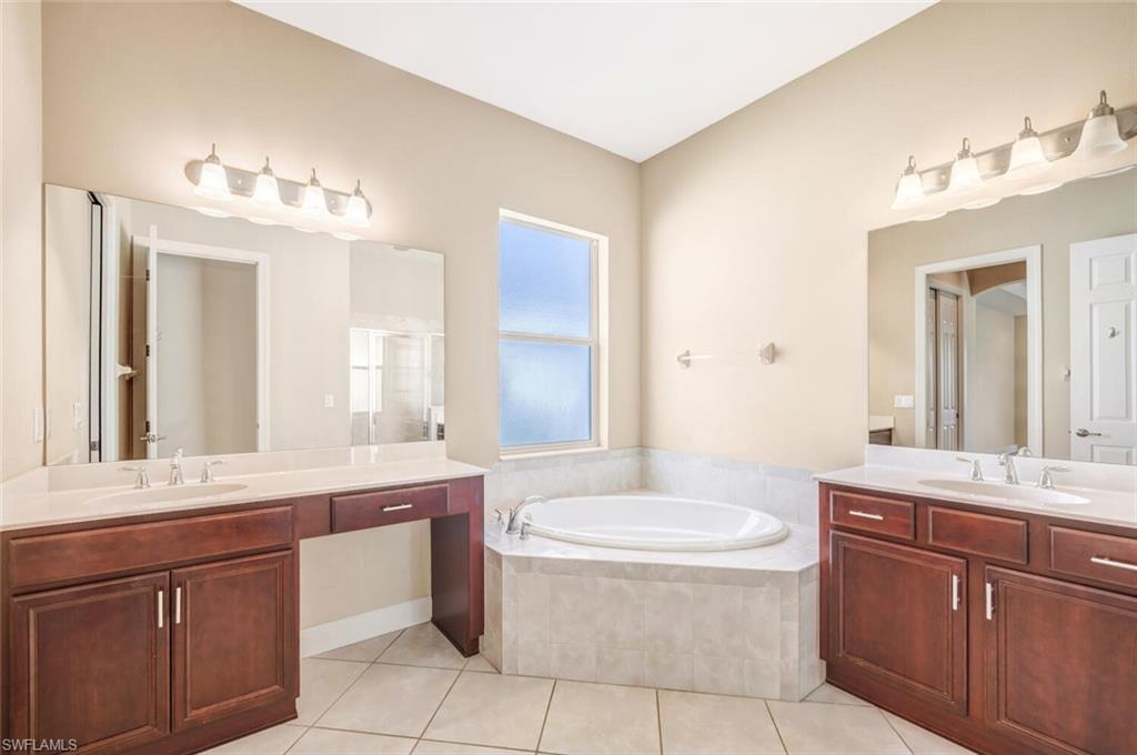 7975 Princeton Drive Naples, FL 34104 - Photo 18 of 28 a bathroom with a granite countertop sink and a mirror