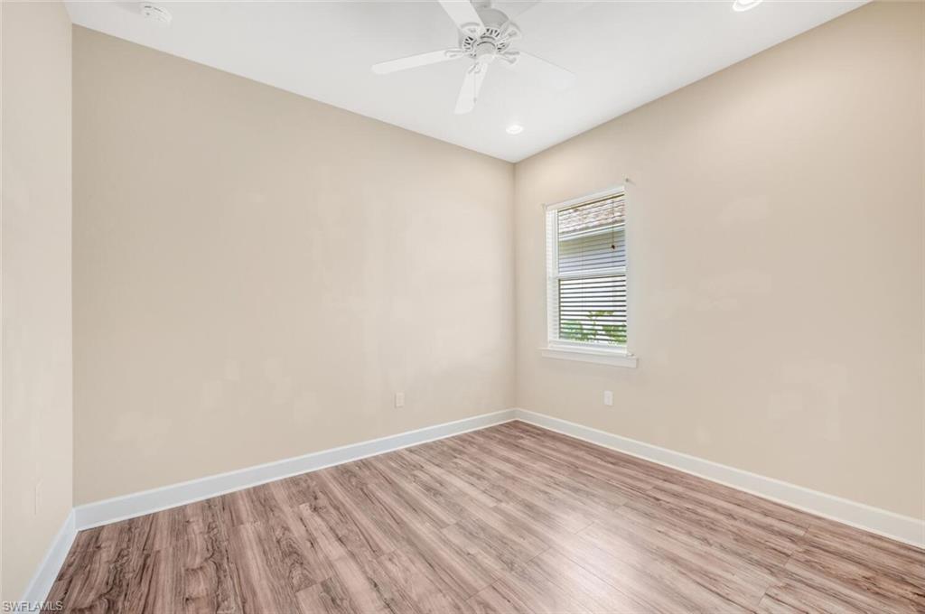 7975 Princeton Drive Naples, FL 34104 - Photo 19 of 28 an empty room with wooden floor and windows