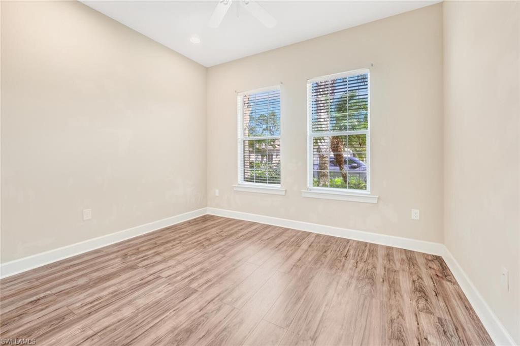 7975 Princeton Drive Naples, FL 34104 - Photo 21 of 28 an empty room with wooden floor and windows