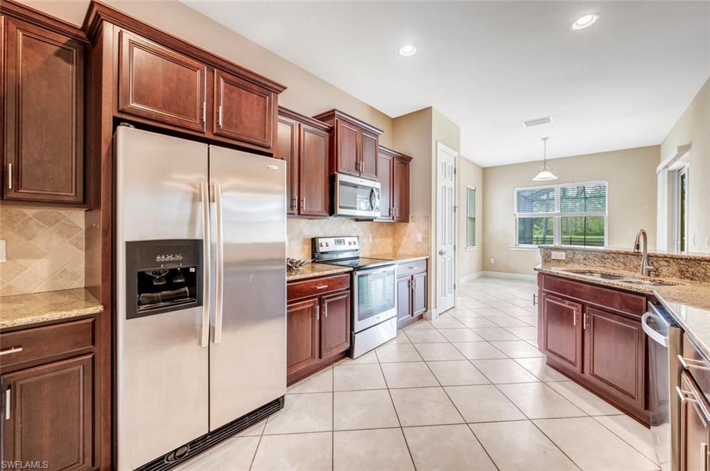 7975 Princeton Drive Naples, FL 34104 - Photo 6 of 28 a large kitchen with stainless steel appliances granite countertop a refrigerator and a stove